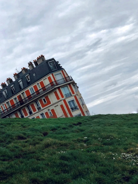 a tall, multicolored building has a wind vane on its roof