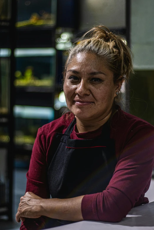 a woman in a kitchen with her arms crossed