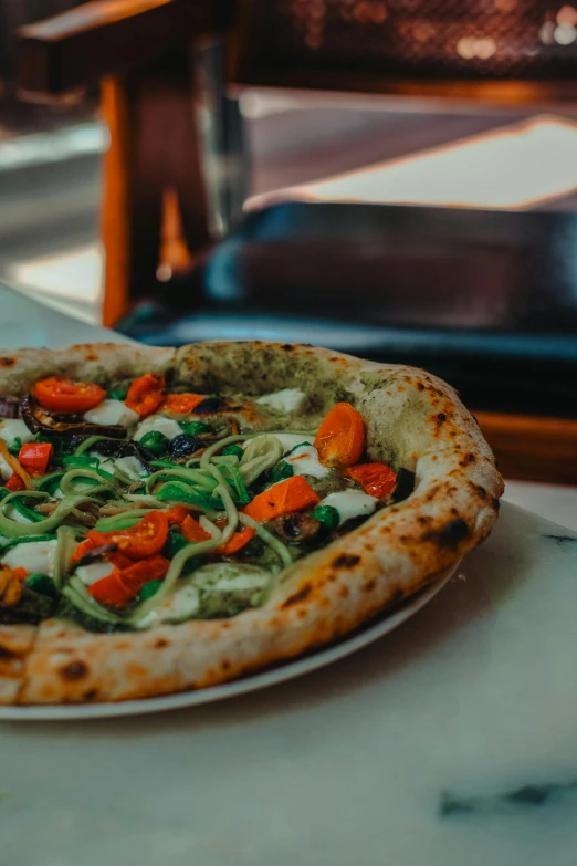 a pizza with vegetables and onions on it sits on a plate