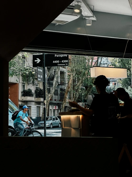 a man sitting at a restaurant in the dark with his bike