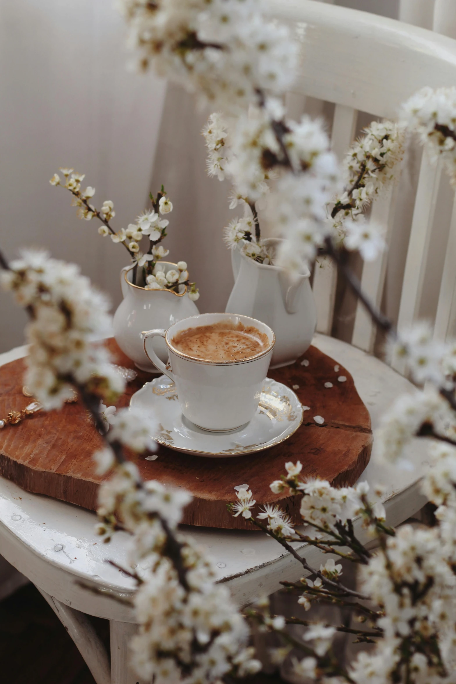 cup of coffee on saucer with flower on table