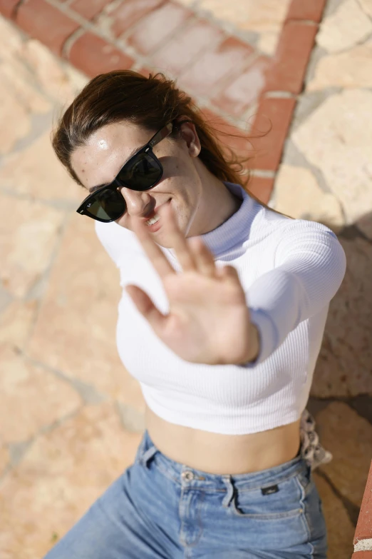 woman with sun glasses making a peace sign