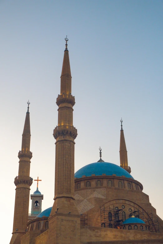 the roof of the mosque looks blue and has tall spires