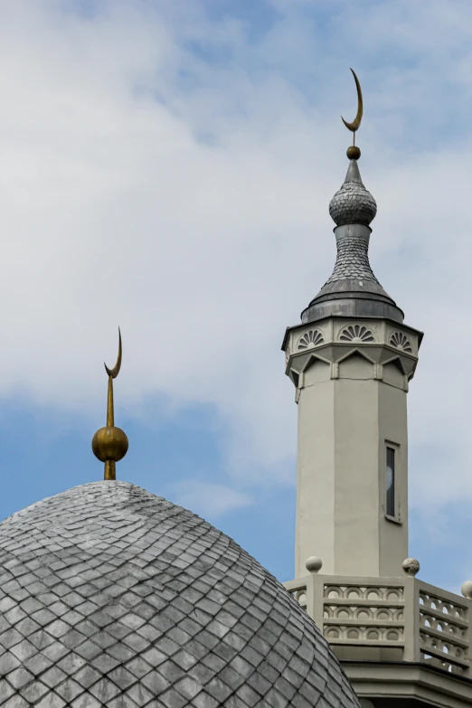 the roof is made of cement with a round tower, and a crescent - shaped roof top