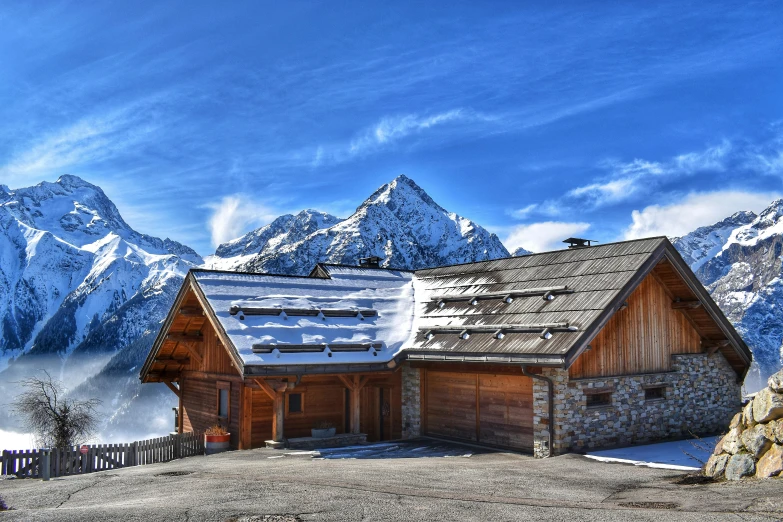 a mountain lodge on the slopes in front of snow covered mountains