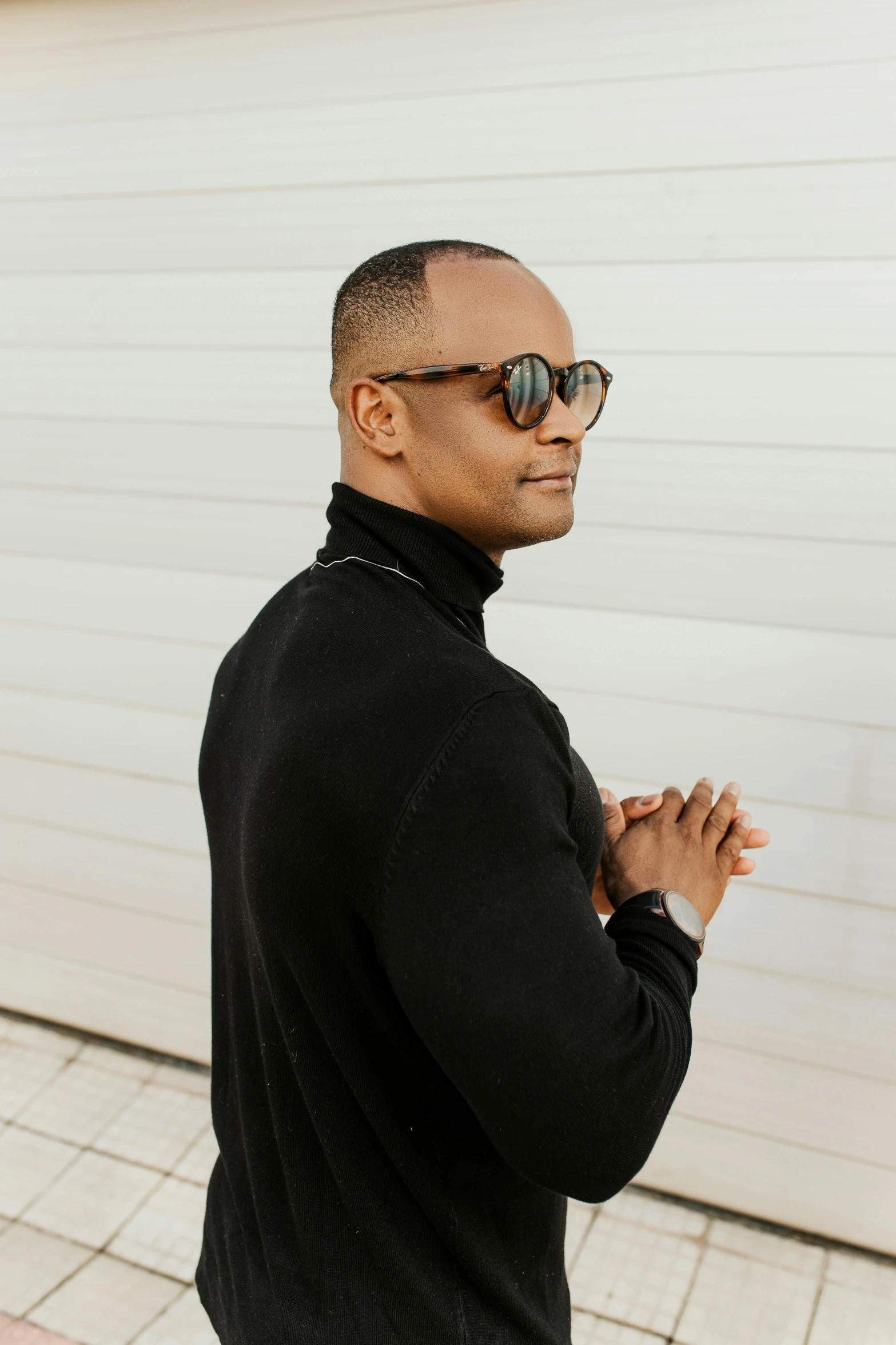 man with sunglasses on his face outside of a house