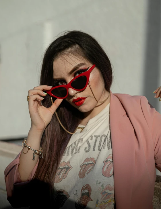 a woman holding red glasses on her face