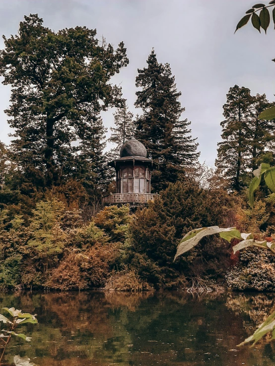 a cabin is in the woods next to water