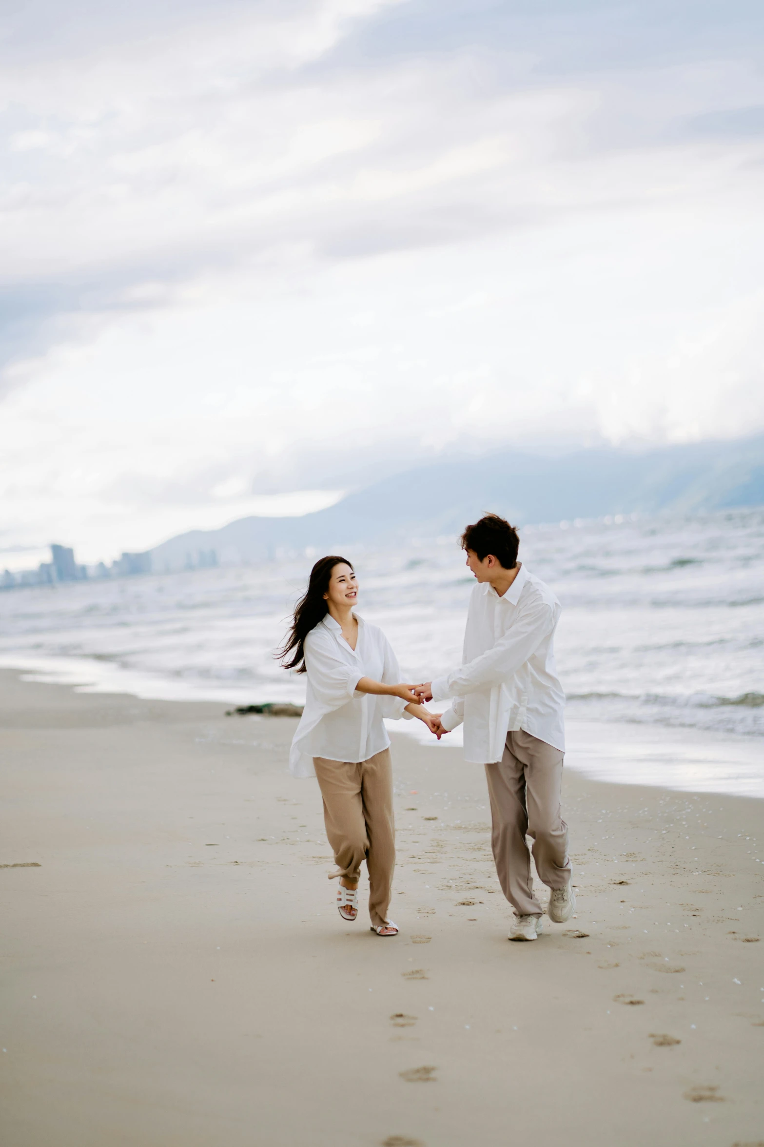 two people walking on the beach holding hands