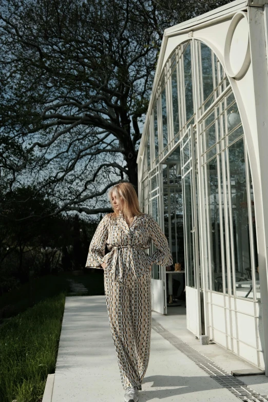 a woman in a dress and sunglasses walking