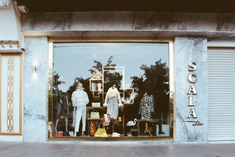 a store front that has a large window with clothing displayed in it