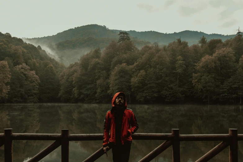 a woman standing next to the edge of a wooden bridge