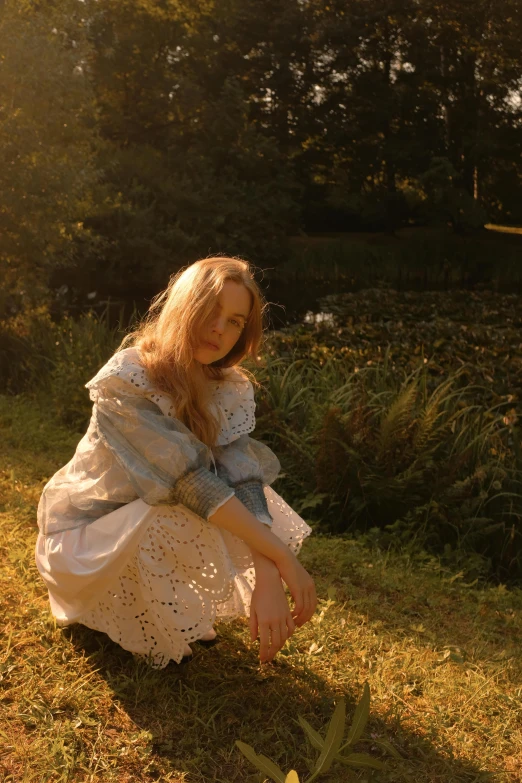 a young woman is kneeling on the grass with a frisbee in her hand