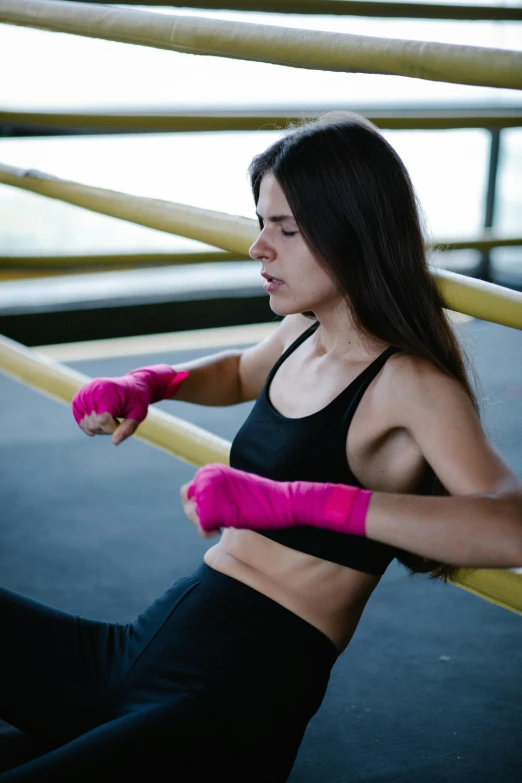 a woman with pink gloves holding onto bars