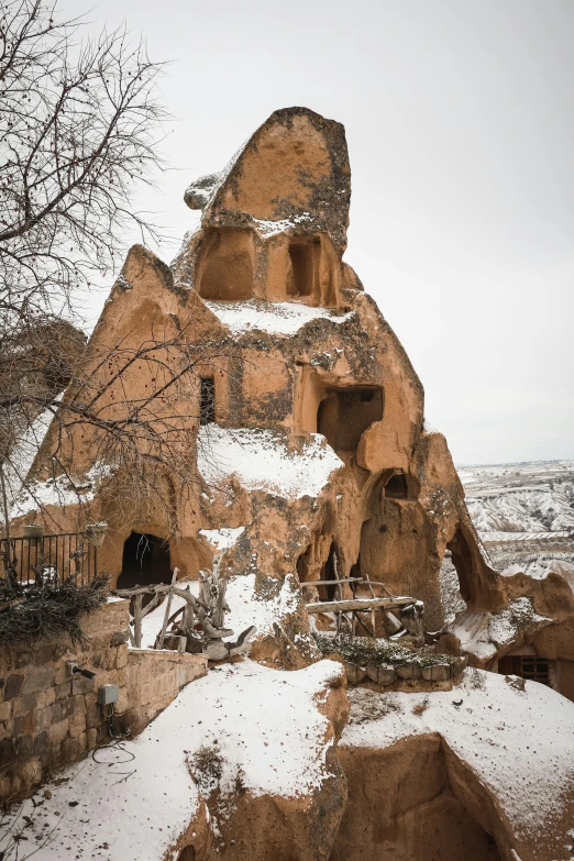 an ancient building is built into a cliff that stands out on the snow