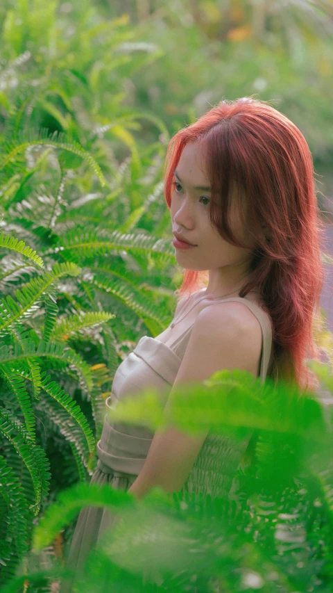 a girl with red hair walking through tall grass