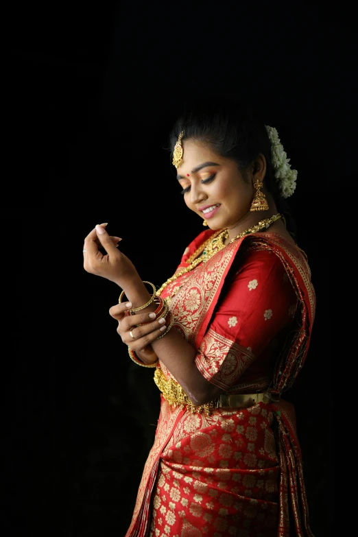 a woman in an indian dress is looking down on her cell phone