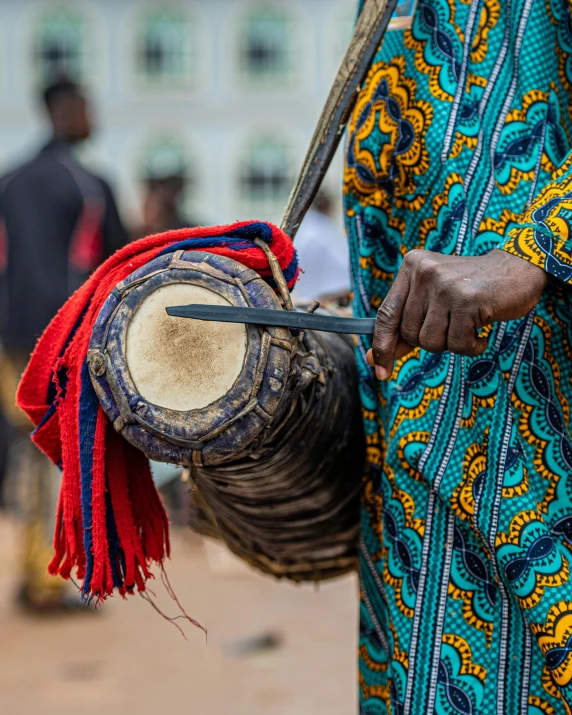 the woman is carrying an old drum while others watch