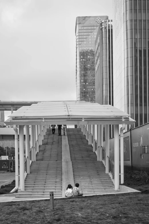 a couple of people sit under a covered walkway
