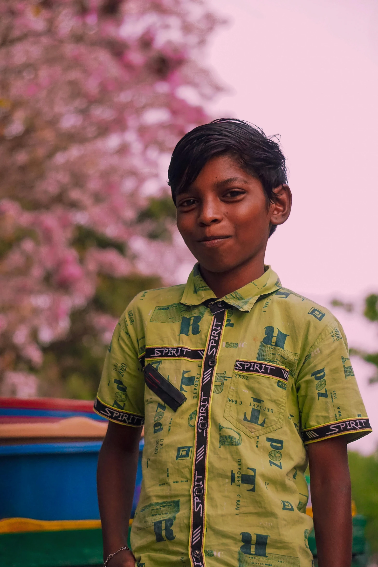 a  wearing a yellow shirt with a green and blue background