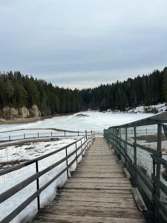 a boardwalk leads out onto a snowy, frozen river