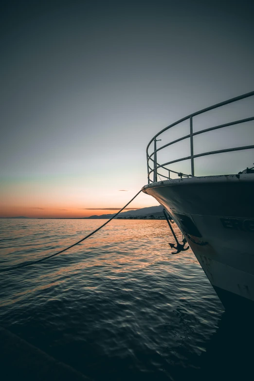 a boat sailing in the ocean at sunset