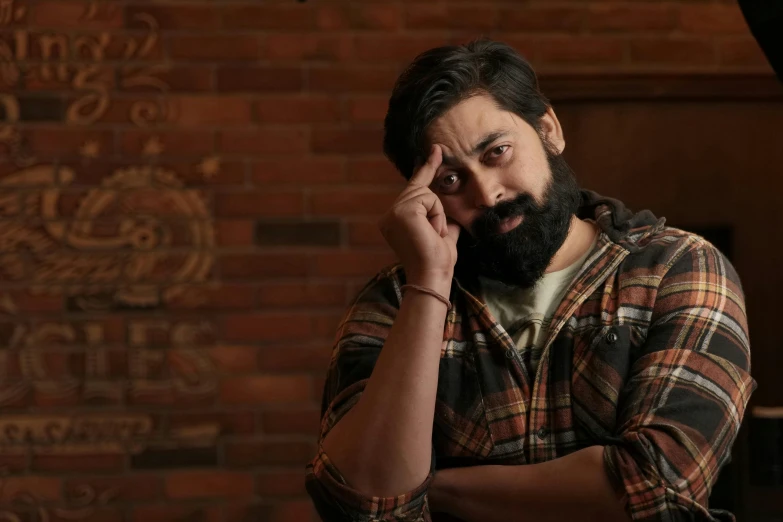 a man with a beard and plaid shirt holding a cell phone