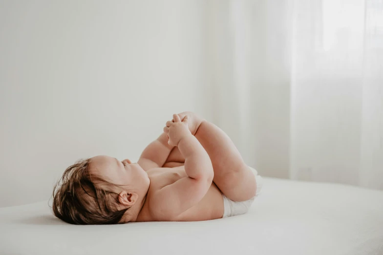 an image of a  baby in diapers on a bed