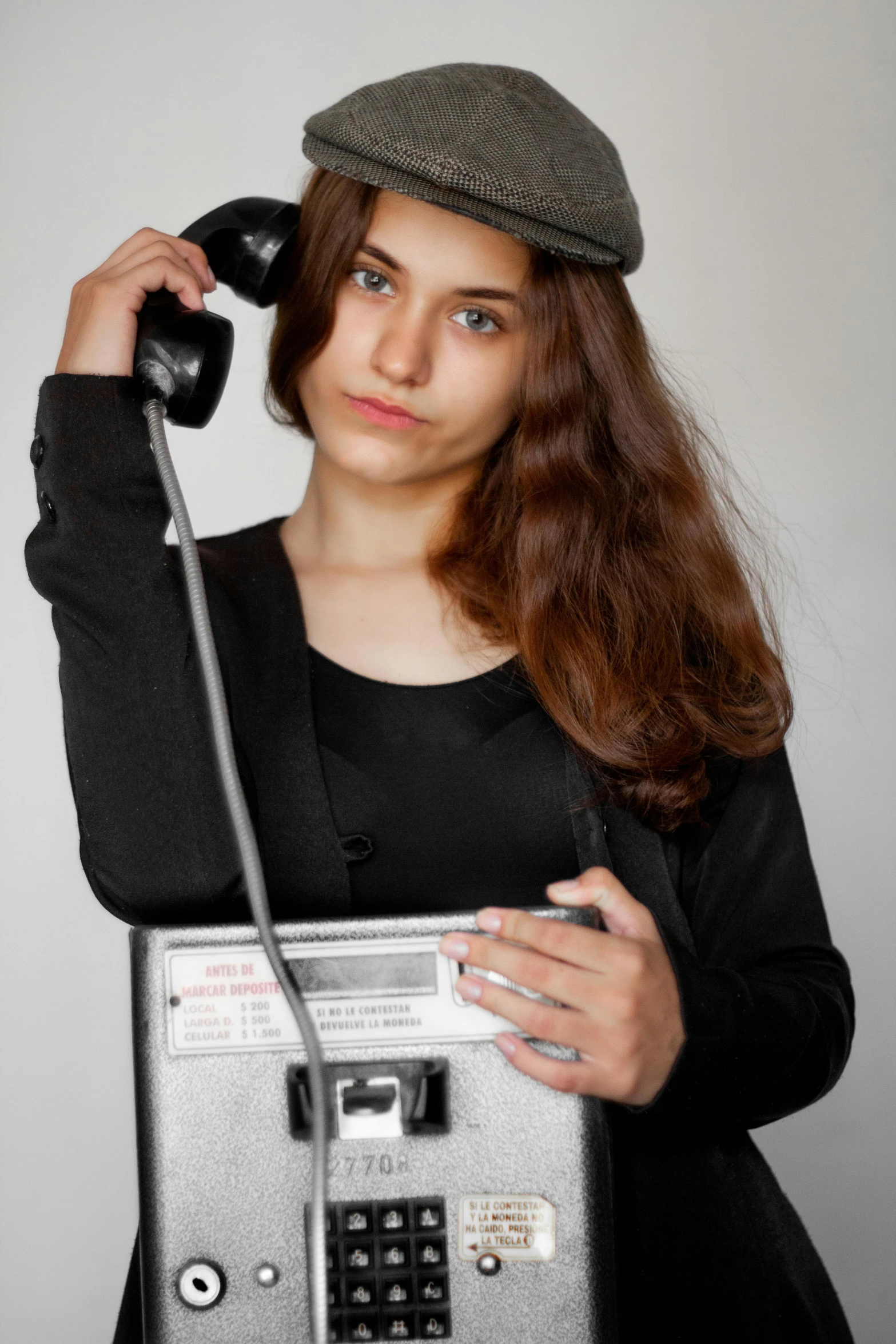 a young woman holding a silver radio with a cord in it