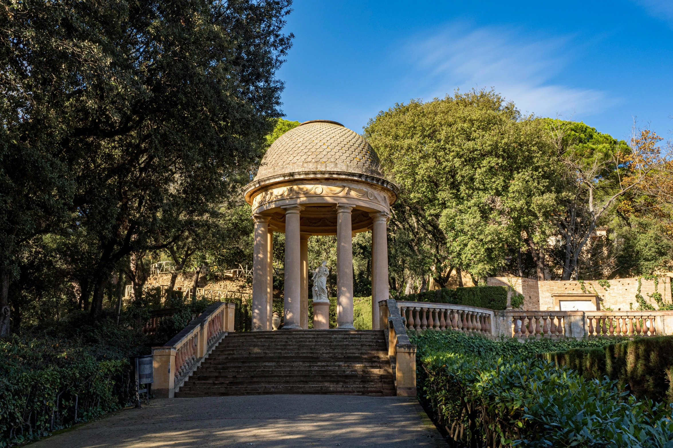 an gazebo surrounded by some green shrubs