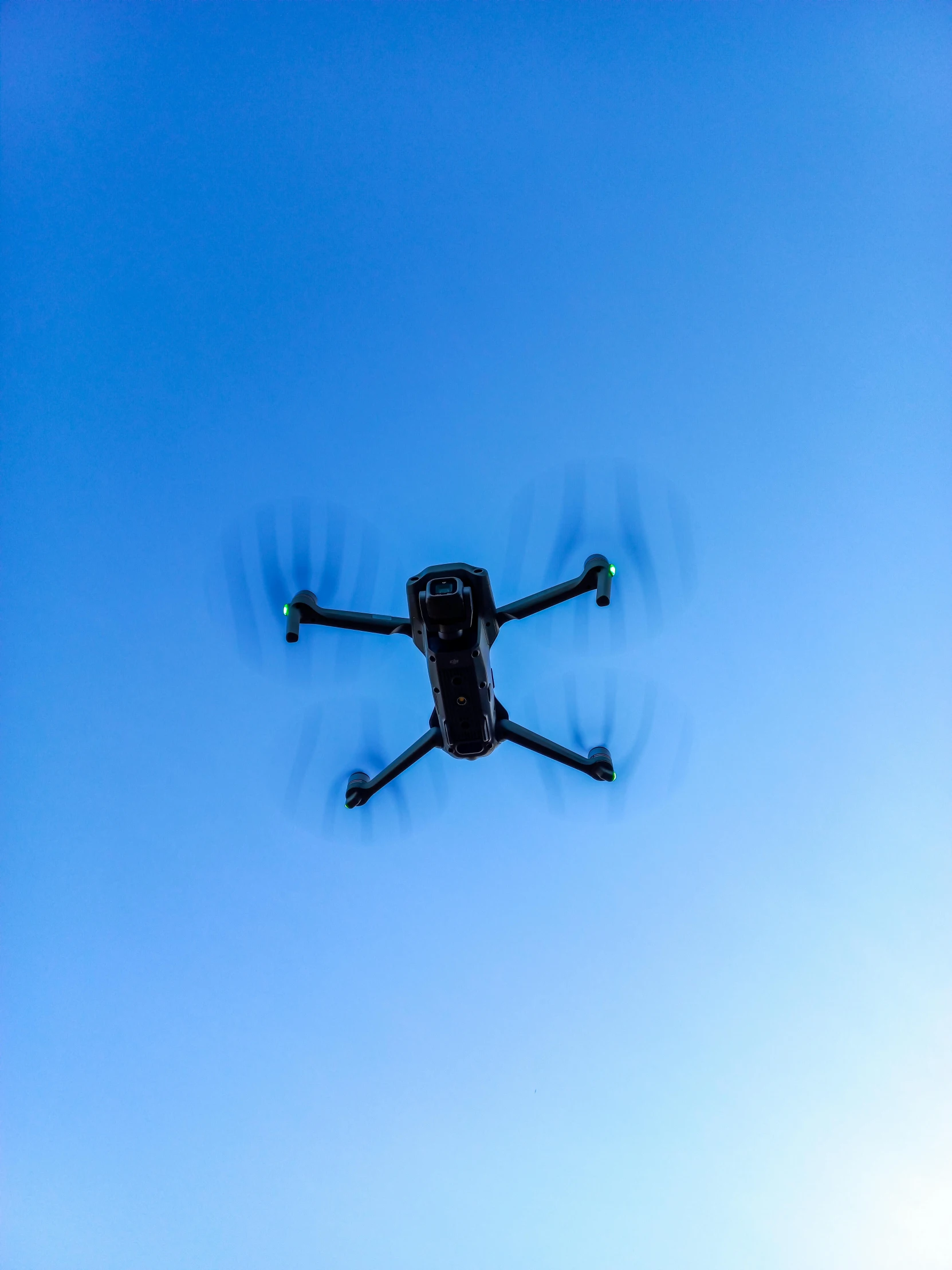 a black helicopter flying in the air while being viewed from below