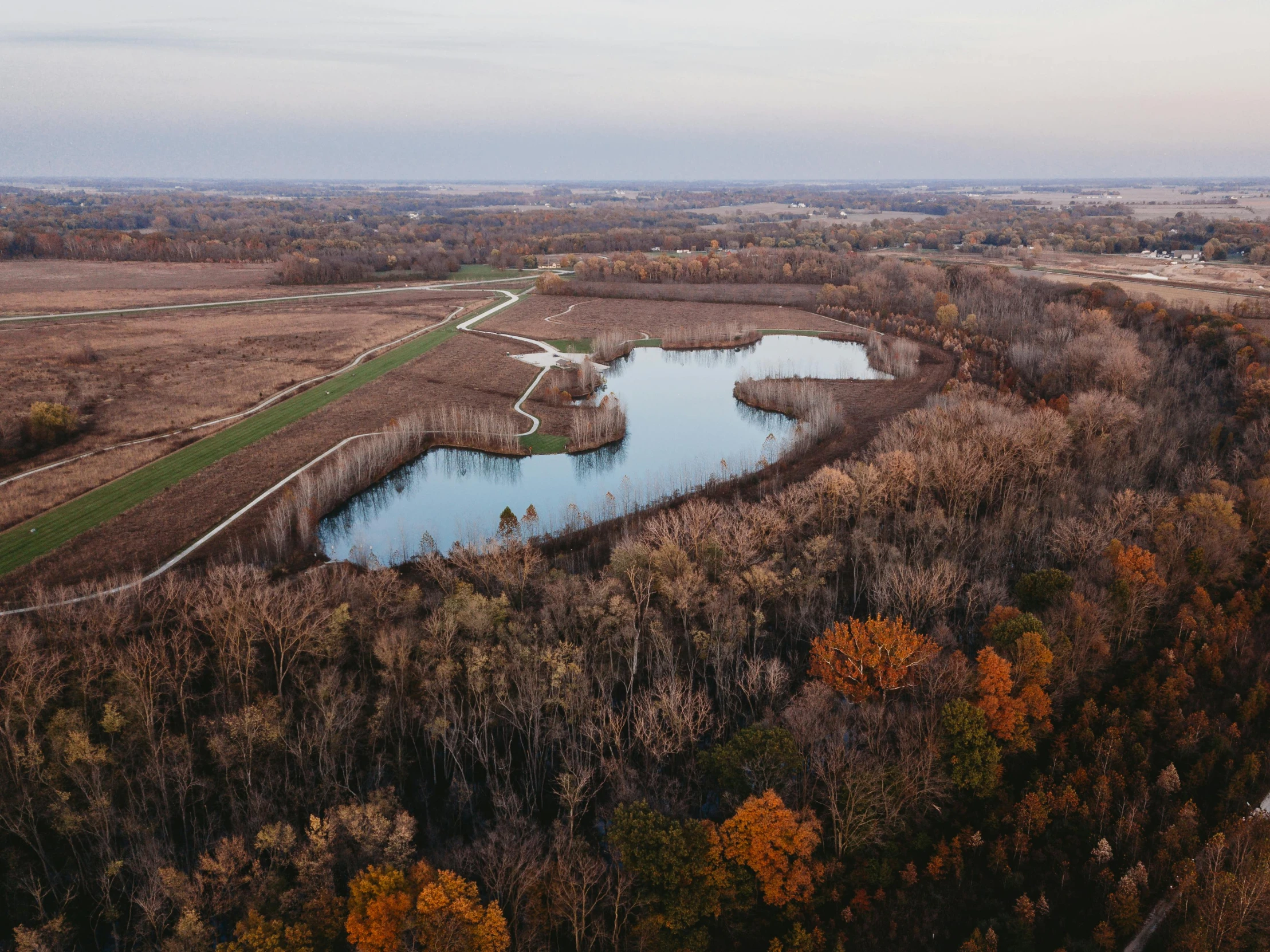 an aerial view of the field, water and trees