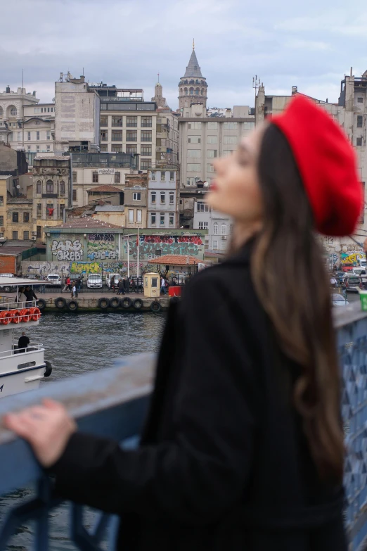 a woman in a red hat looking out over the water