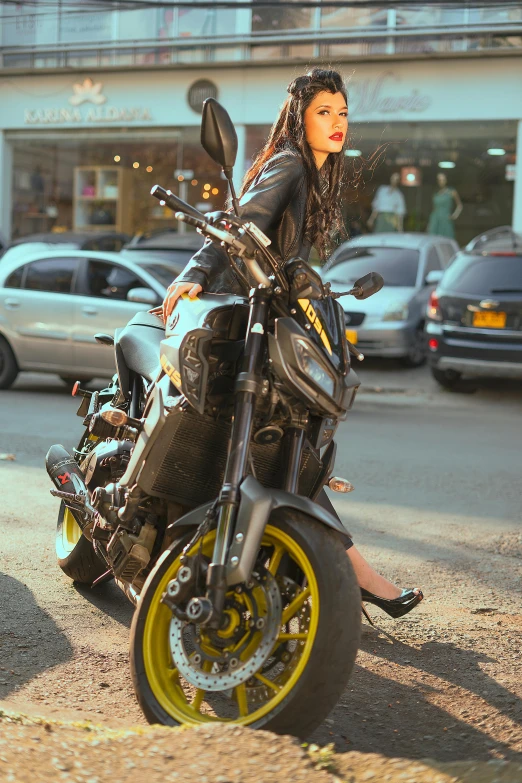 lady sitting on her motorcycle on a street in a leather outfit