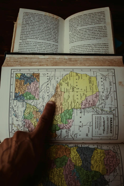 an open book showing maps of countries and their locations