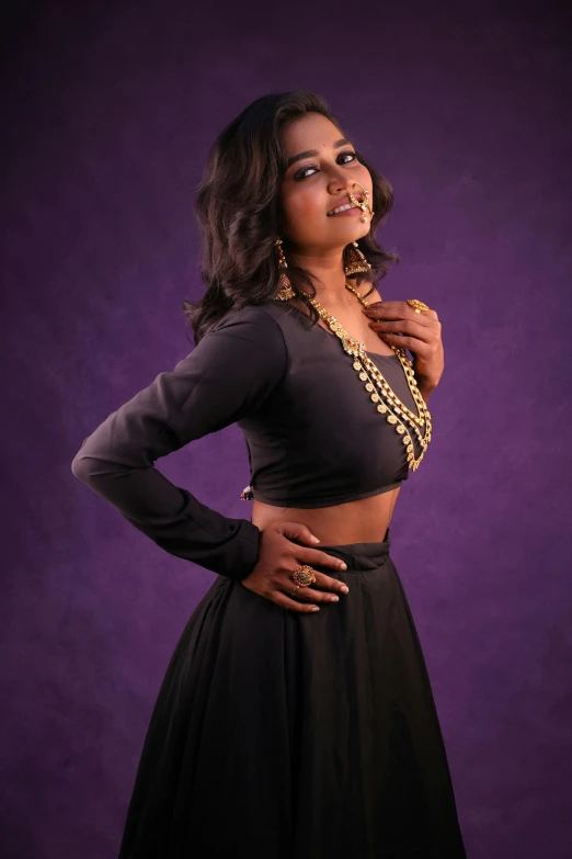 a black woman standing in a short skirt and gold necklace