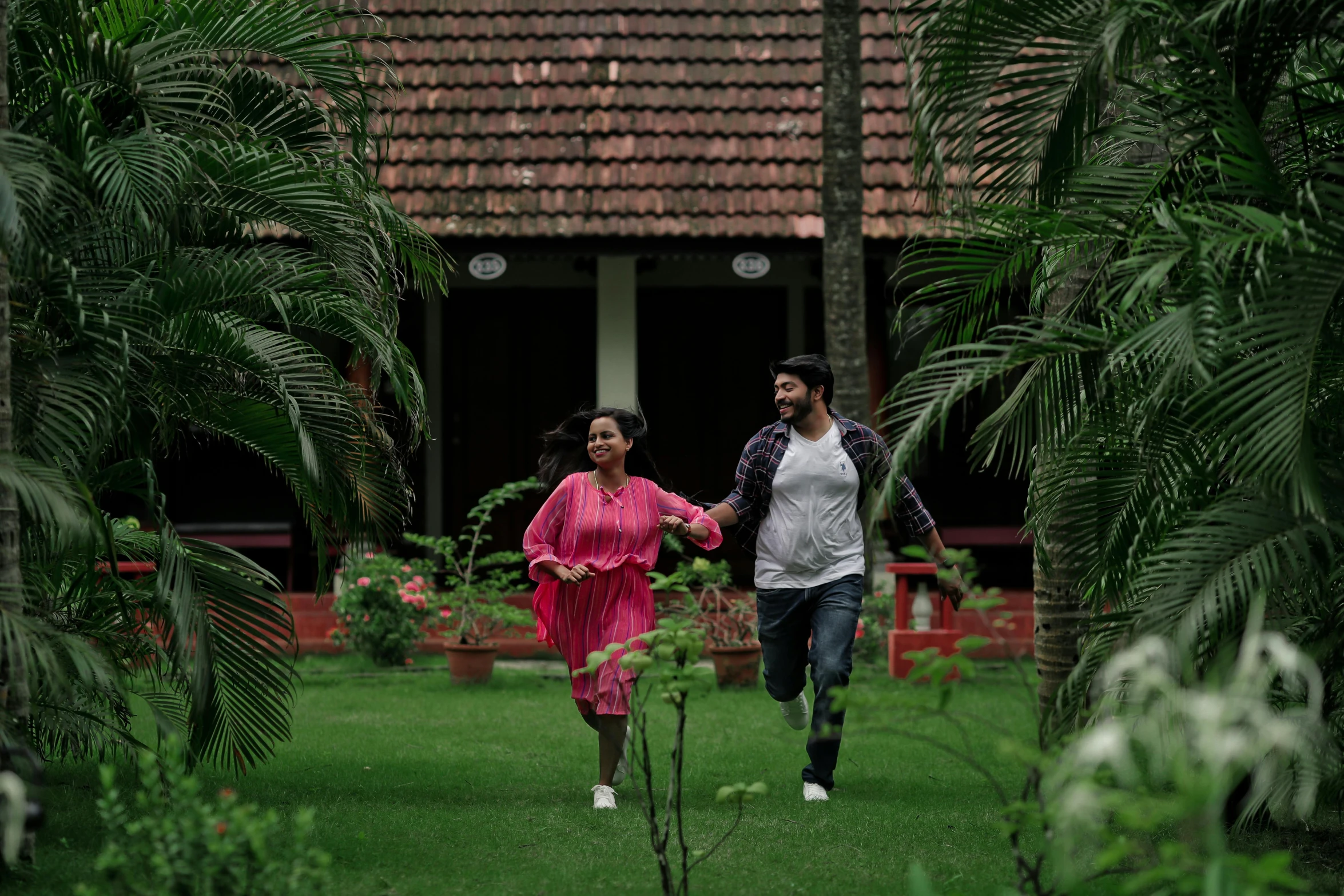 a couple running in a park holding hands