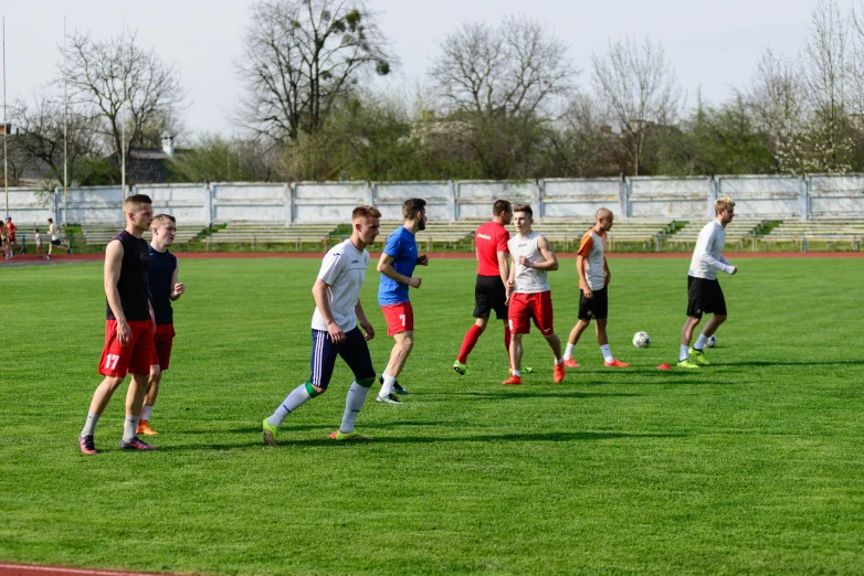 men playing soccer in a large grassy field