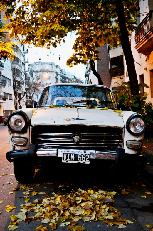 an old car is parked on the side of the street