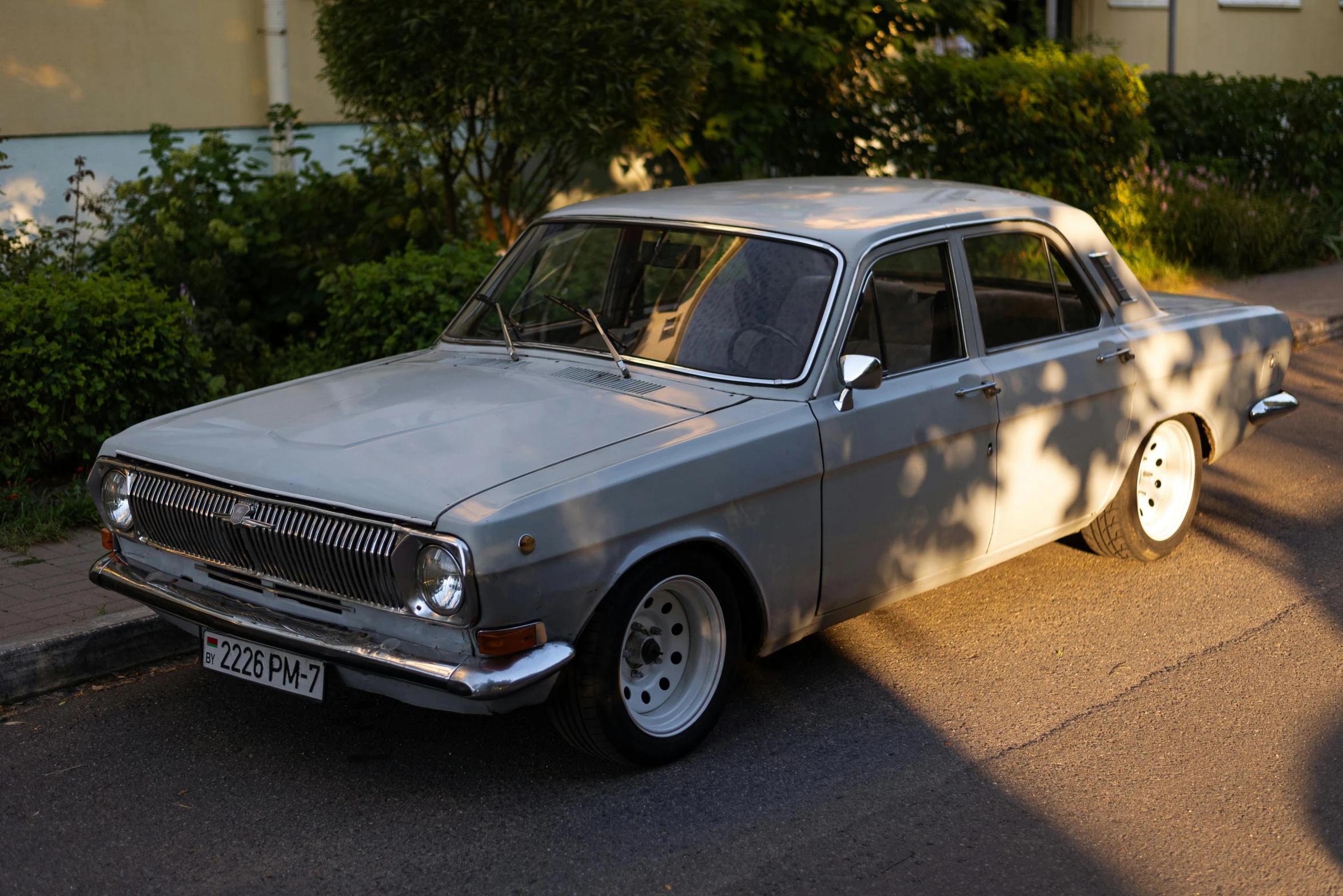 an old car is parked on a city street