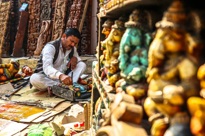 a person sitting on the ground in front of various decorative items