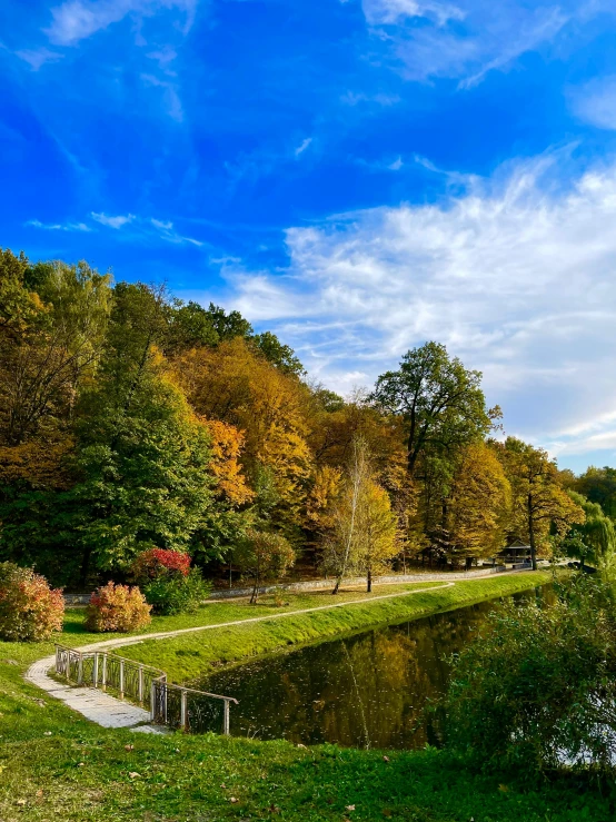 a bridge in front of a lake surrounded by trees