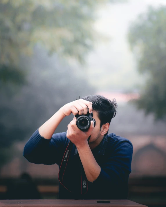 a man holding a camera up to his face