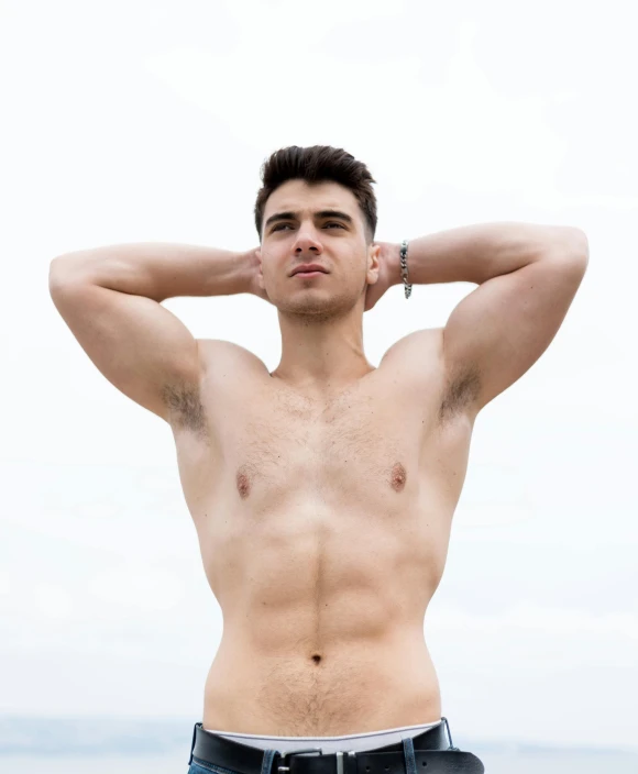 shirtless man posing for a picture in the grass