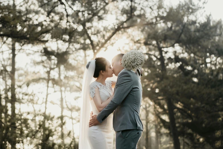 a newly married couple standing in the woods