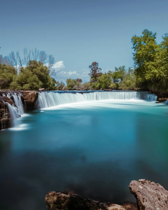 the small waterfall is very high above the water