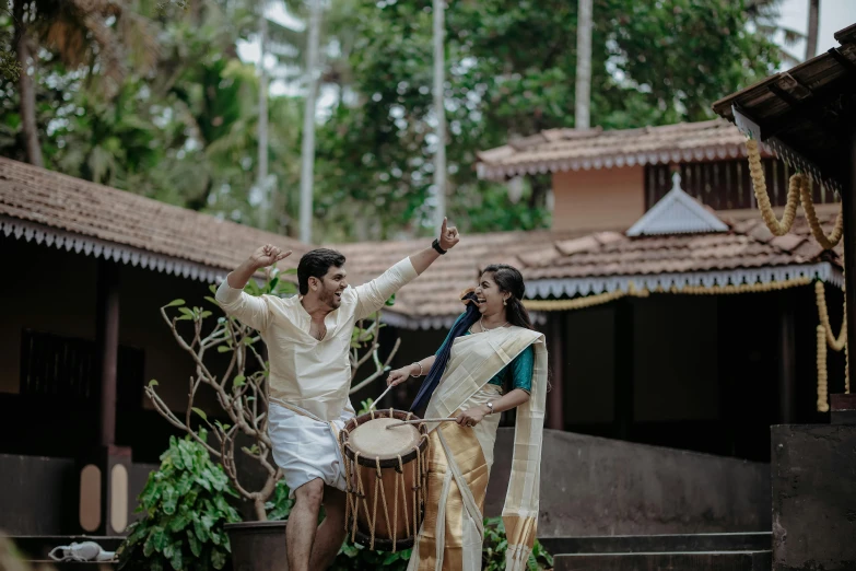 two people standing in the grass holding drums