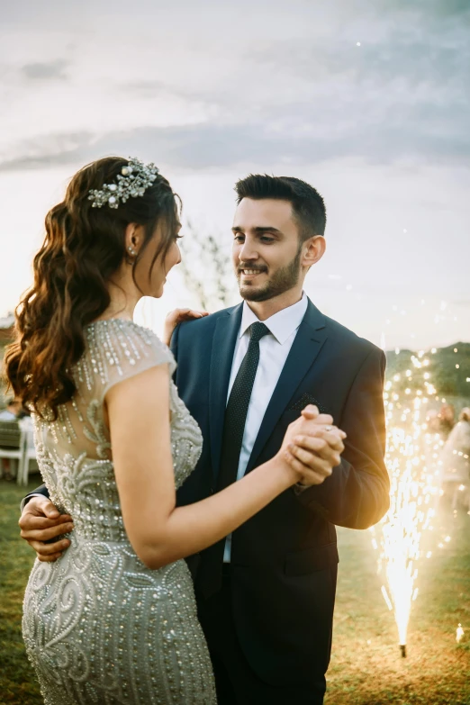 a man and woman standing by a fireworks at their wedding