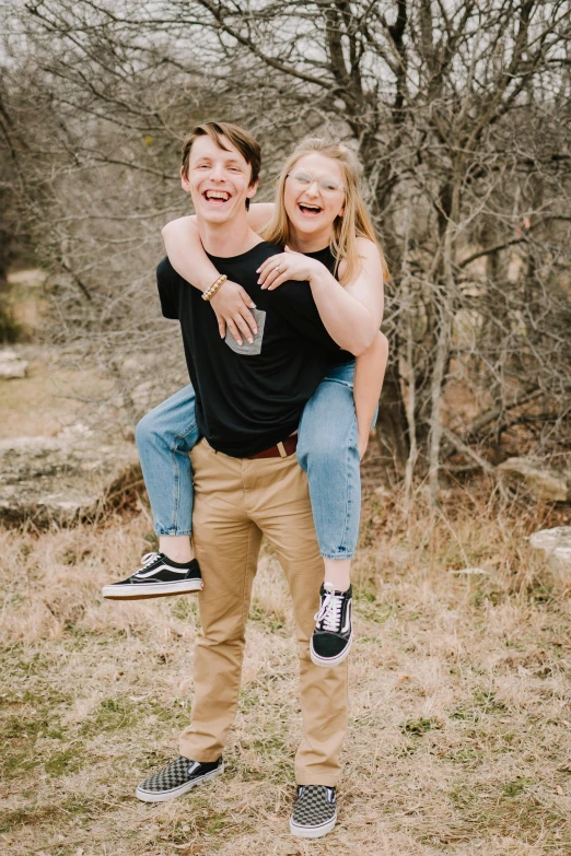 a girl holding up another person's head while the boy is sitting on his shoulders