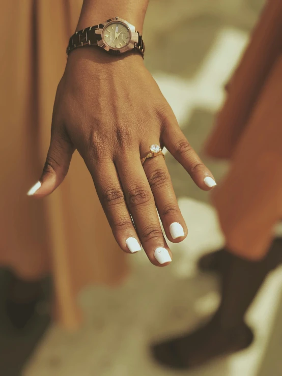 a woman holding onto her wrist with her hand with one finger and two of her other hands with the other